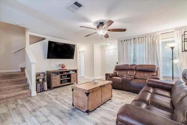 217 Adriana Ln, Hutto, TX 78634 - living room with light wood-style flooring, stairs, ceiling fan, and ornamental molding