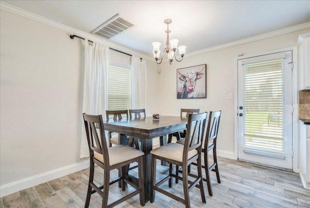 217 Adriana Ln, Hutto, TX 78634 - dining area with ornamental molding, a chandelier, and light wood-style flooring