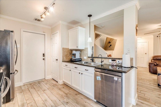 217 Adriana Ln, Hutto, TX 78634 - kitchen featuring appliances with stainless steel finishes, light wood finished floors, white cabinetry, tasteful backsplash, and pendant lighting