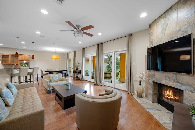 5715 Misty Hill Cv, Austin, TX 78759 - living room featuring a tile fireplace, recessed lighting, light wood finished floors, and ceiling fan