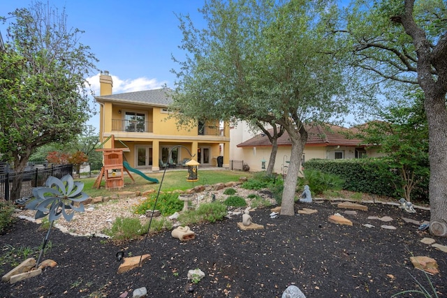 5715 Misty Hill Cv, Austin, TX 78759 - rear view of house with a balcony, a playground, stucco siding, and a chimney