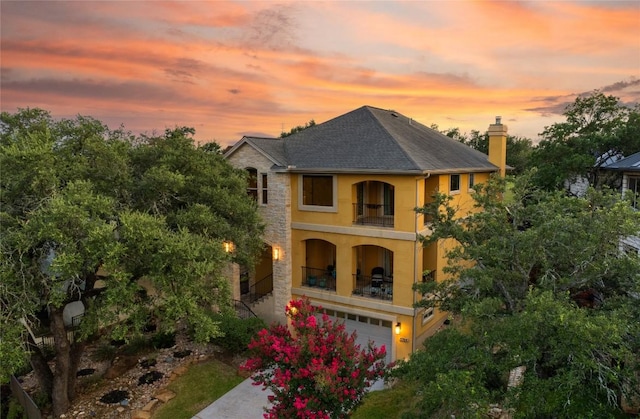 5715 Misty Hill Cv, Austin, TX 78759 - view of front facade featuring a balcony, stucco siding, a garage, a chimney, and a shingled roof