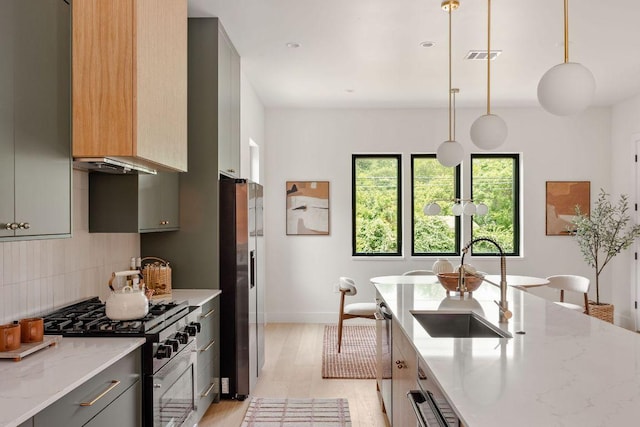 505 Philco Dr Unit 3, Austin, TX 78745 - kitchen featuring gas range, stainless steel refrigerator with ice dispenser, backsplash, light wood-type flooring, and light stone counters