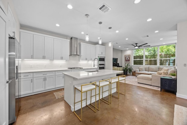 4602 Alf Ave Unit B, Austin, TX 78721 - kitchen featuring wall chimney exhaust hood, finished concrete flooring, recessed lighting, stainless steel appliances, and tasteful backsplash