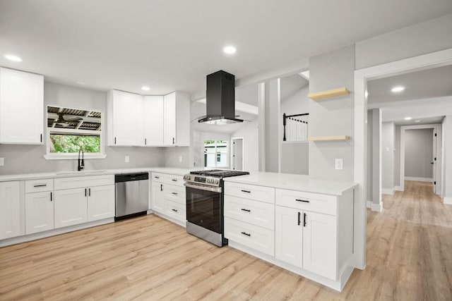 11462 Bristle Oak Trl, Austin, TX 78750 - kitchen featuring appliances with stainless steel finishes, island range hood, light countertops, light wood finished floors, and white cabinetry