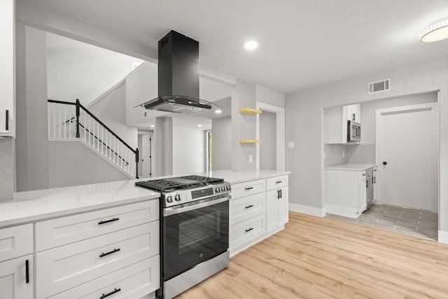 11462 Bristle Oak Trl, Austin, TX 78750 - kitchen featuring stainless steel appliances, island exhaust hood, white cabinets, light wood-type flooring, and recessed lighting