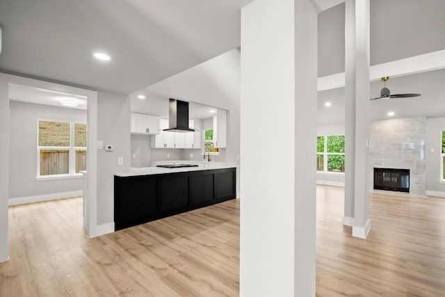 11462 Bristle Oak Trl, Austin, TX 78750 - kitchen featuring wall chimney exhaust hood, light countertops, white cabinetry, light wood finished floors, and recessed lighting