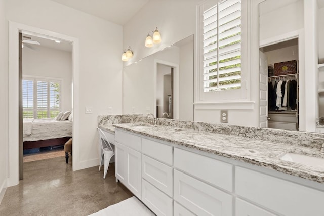 503 Alva Dr, Spicewood, TX 78669 - bathroom featuring double vanity, a ceiling fan, connected bathroom, concrete floors, and a spacious closet