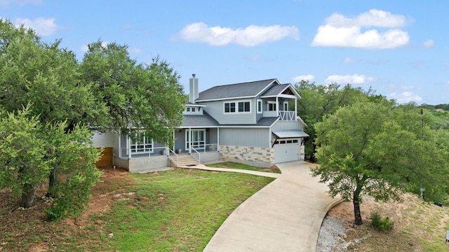 503 Alva Dr, Spicewood, TX 78669 - traditional-style home with a porch, concrete driveway, an attached garage, a chimney, and stone siding