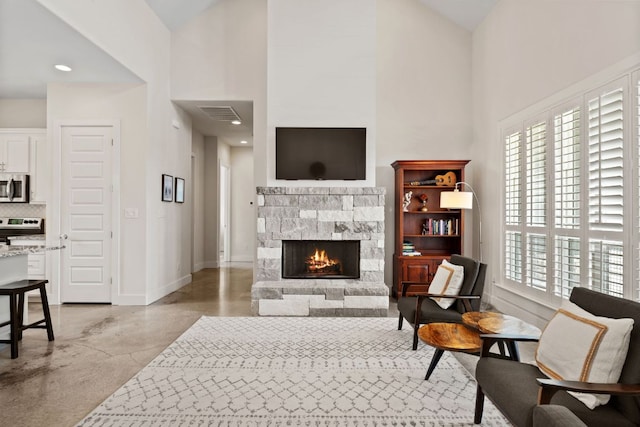 503 Alva Dr, Spicewood, TX 78669 - living room with high vaulted ceiling, concrete flooring, and a fireplace