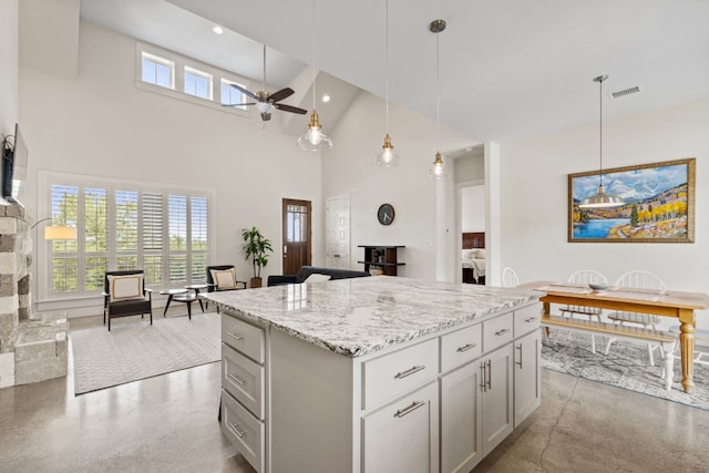 503 Alva Dr, Spicewood, TX 78669 - kitchen with a high ceiling, ceiling fan, finished concrete floors, a kitchen island, and pendant lighting