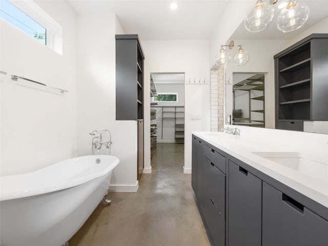 1605 Garden St, Austin, TX 78702 - bathroom featuring concrete floors, a freestanding bath, double vanity, a walk in closet, and recessed lighting