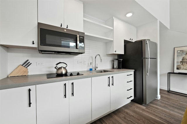 49 Navasota St Unit 216, Austin, TX 78702 - kitchen with stainless steel appliances, open shelves, dark wood-style flooring, white cabinetry, and backsplash