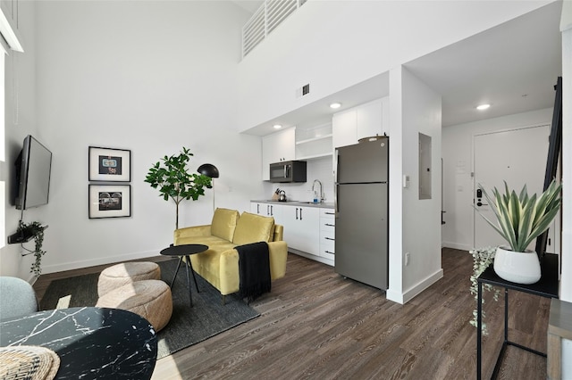 49 Navasota St Unit 216, Austin, TX 78702 - living room with dark wood finished floors, electric panel, and recessed lighting