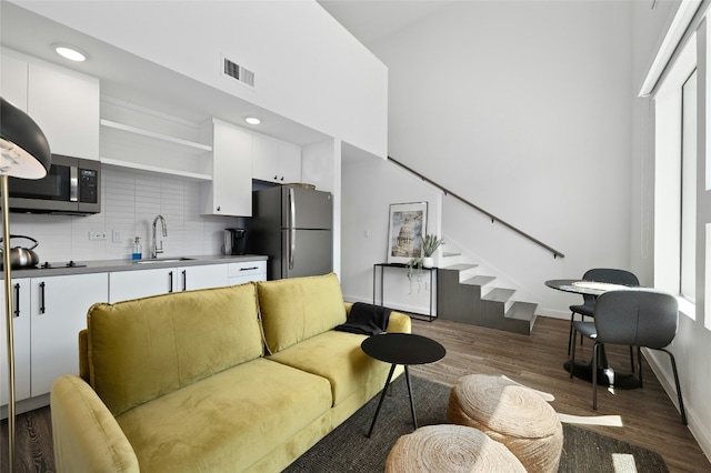 49 Navasota St Unit 216, Austin, TX 78702 - living area with dark wood finished floors, stairs, recessed lighting, and a towering ceiling