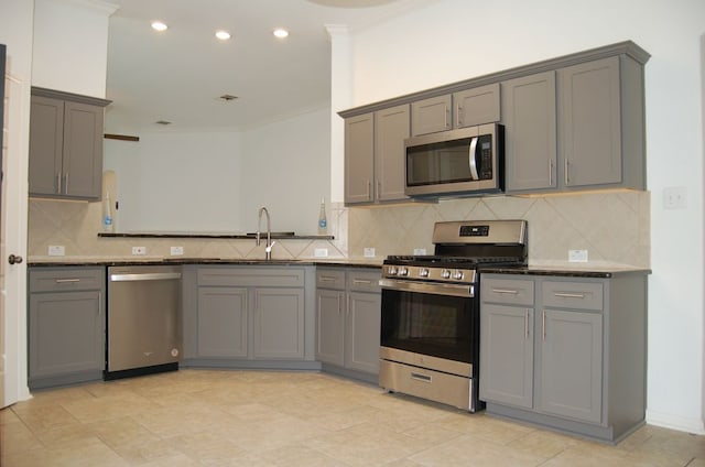4216 Veiled Falls Dr, Pflugerville, TX 78660 - kitchen featuring appliances with stainless steel finishes, gray cabinetry, ornamental molding, backsplash, and recessed lighting