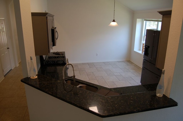 4216 Veiled Falls Dr, Pflugerville, TX 78660 - kitchen with dark stone countertops, pendant lighting, refrigerator with ice dispenser, ornamental molding, and a peninsula