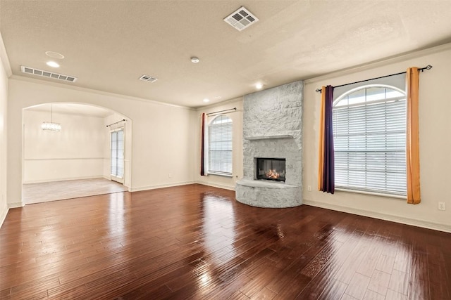 2908 Arbor Ct, Round Rock, TX 78681 - unfurnished living room with arched walkways, wood-type flooring, a fireplace, ornamental molding, and recessed lighting
