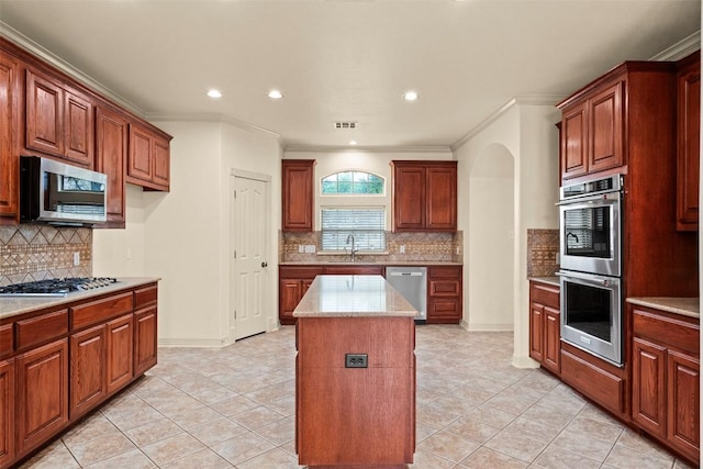 2908 Arbor Ct, Round Rock, TX 78681 - kitchen with stainless steel appliances, arched walkways, backsplash, a center island, and crown molding