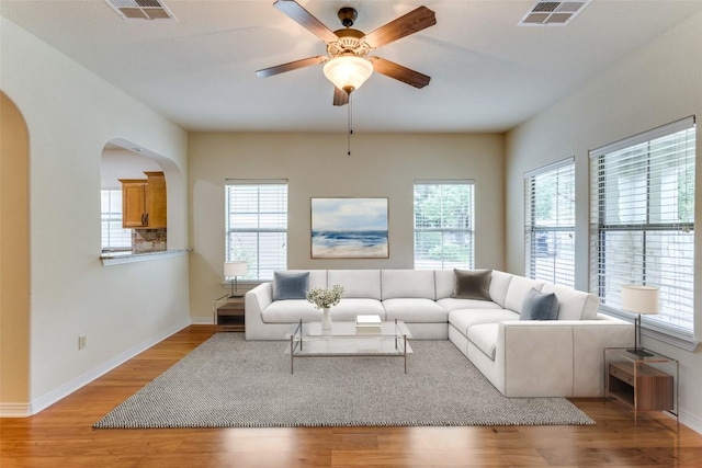 13604 Caldwell Dr Unit 72, Austin, TX 78750 - living room with light wood finished floors, arched walkways, and a ceiling fan