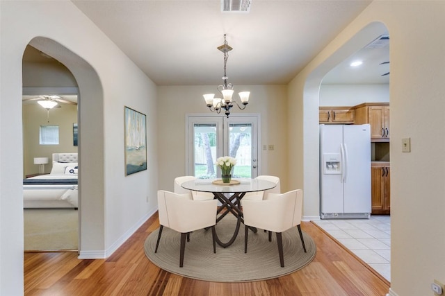 13604 Caldwell Dr Unit 72, Austin, TX 78750 - dining room featuring arched walkways, a chandelier, and light wood-type flooring