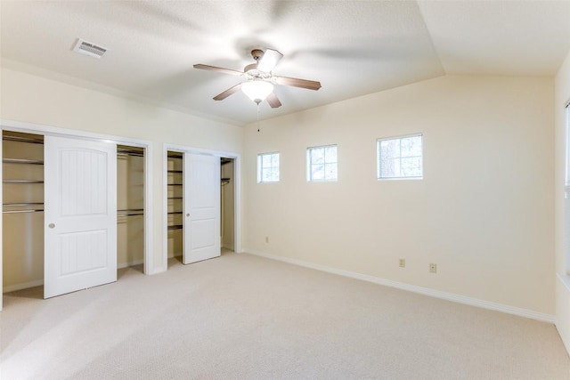 13604 Caldwell Dr Unit 72, Austin, TX 78750 - unfurnished bedroom with light carpet, multiple closets, and ceiling fan