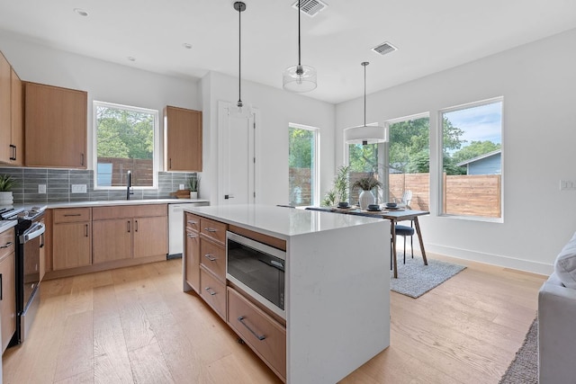 6406 Cannonleague Dr Unit 2, Austin, TX 78745 - kitchen featuring stainless steel microwave, range with electric stovetop, white dishwasher, light wood-type flooring, and plenty of natural light