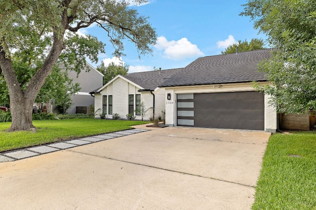 2709 Jorwoods Dr, Austin, TX 78745 - view of front of home with concrete driveway, a garage, a front lawn, roof with shingles, and brick siding
