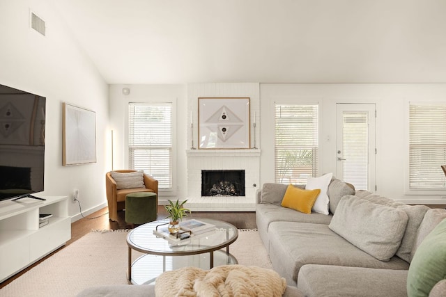 2709 Jorwoods Dr, Austin, TX 78745 - living room featuring a brick fireplace, lofted ceiling, and wood finished floors