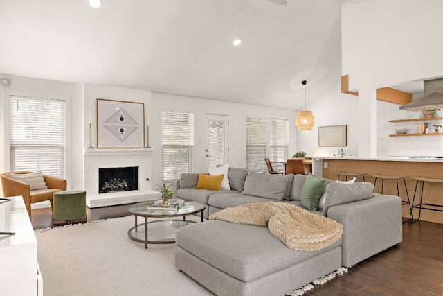 2709 Jorwoods Dr, Austin, TX 78745 - living area with dark wood-style floors, a brick fireplace, vaulted ceiling, and recessed lighting