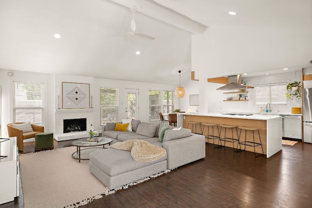 2709 Jorwoods Dr, Austin, TX 78745 - living room with beam ceiling, a brick fireplace, dark wood-style flooring, ceiling fan, and recessed lighting