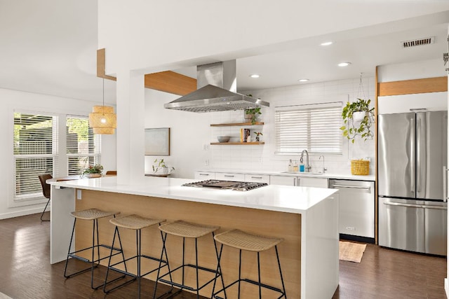 2709 Jorwoods Dr, Austin, TX 78745 - kitchen featuring appliances with stainless steel finishes, wall chimney range hood, a kitchen breakfast bar, white cabinetry, and dark wood finished floors