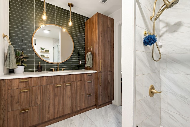 2709 Jorwoods Dr, Austin, TX 78745 - bathroom featuring a tile shower, vanity, tasteful backsplash, tile walls, and marble look tiles