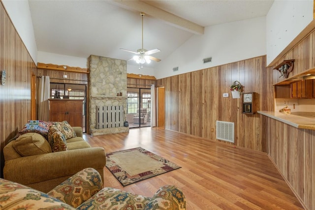 344 Fm 2984th Rd, Luling, TX 78648 - living room featuring wood walls, beamed ceiling, light wood finished floors, high vaulted ceiling, and a ceiling fan