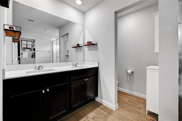 3032 Maryanne Ln, Pflugerville, TX 78660 - bathroom featuring wood finished floors, double vanity, and a shower stall