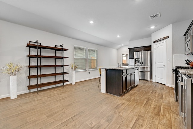 3032 Maryanne Ln, Pflugerville, TX 78660 - kitchen featuring stainless steel appliances, light wood-style floors, a kitchen breakfast bar, recessed lighting, and a kitchen island with sink