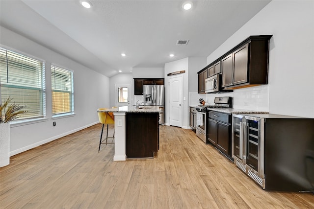 3032 Maryanne Ln, Pflugerville, TX 78660 - kitchen with stainless steel appliances, light wood-type flooring, light stone counters, a kitchen breakfast bar, and recessed lighting
