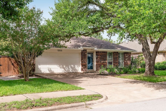 5205 Encinitas Ln, Austin, TX 78749 - view of front of property featuring driveway, brick siding, a garage, and a shingled roof