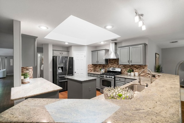 5205 Encinitas Ln, Austin, TX 78749 - kitchen with gray cabinetry, stainless steel appliances, tasteful backsplash, a peninsula, and light wood-type flooring