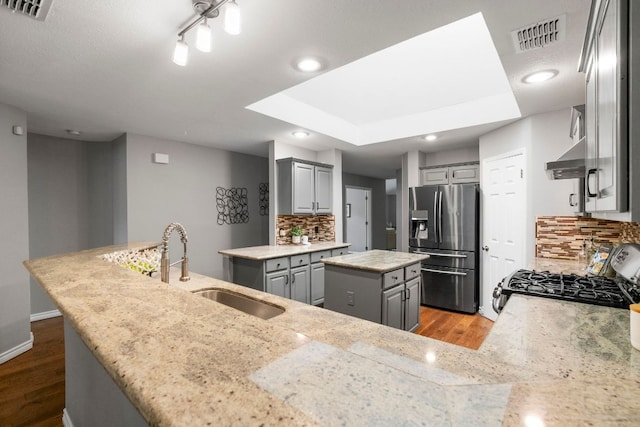 5205 Encinitas Ln, Austin, TX 78749 - kitchen featuring gray cabinets, wood finished floors, stainless steel fridge, range with gas cooktop, and a kitchen island
