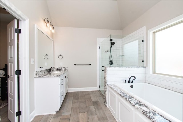 2050 Chalk Mill Xing, Salado, TX 76571 - full bathroom with a shower stall, vanity, a garden tub, vaulted ceiling, and wood finished floors