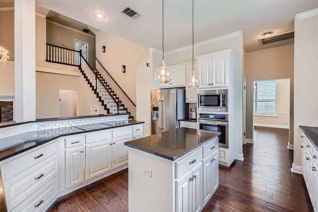 2114 Cliffs Edge Dr, Austin, TX 78733 - kitchen with appliances with stainless steel finishes, dark wood-style flooring, white cabinetry, a center island, and decorative light fixtures