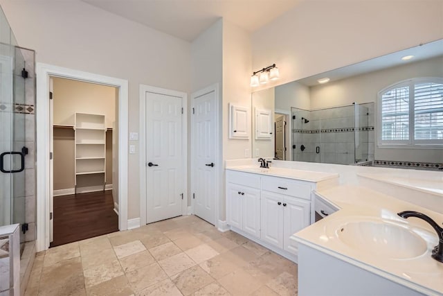 2114 Cliffs Edge Dr, Austin, TX 78733 - bathroom featuring two vanities, a shower stall, and a walk in closet