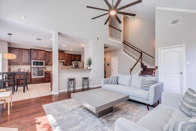 1604 Hughes Dr, Cedar Park, TX 78613 - living area with a ceiling fan, light wood finished floors, a high ceiling, stairway, and recessed lighting