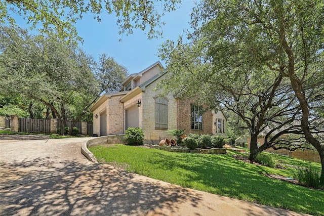 128 Squires Dr, Lakeway, TX 78734 - view of front of home with a garage, concrete driveway, and stone siding