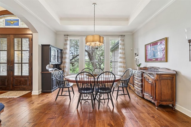 128 Squires Dr, Lakeway, TX 78734 - dining area with a chandelier, arched walkways, hardwood / wood-style flooring, a tray ceiling, and french doors