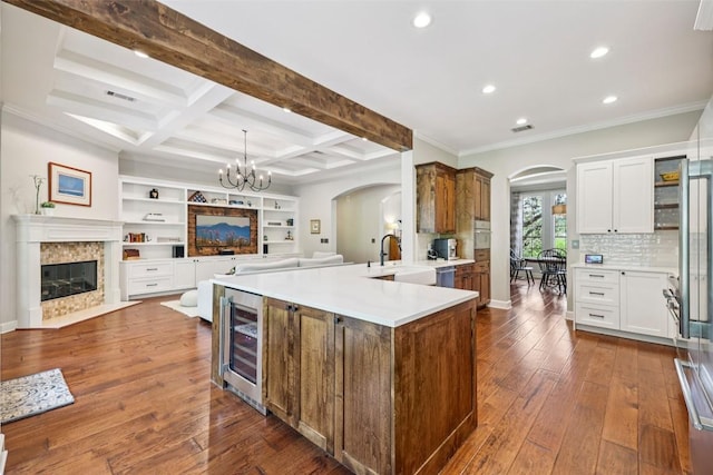 128 Squires Dr, Lakeway, TX 78734 - kitchen featuring arched walkways, wine cooler, recessed lighting, open floor plan, and beam ceiling