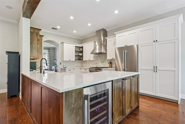 128 Squires Dr, Lakeway, TX 78734 - kitchen featuring wall chimney exhaust hood, beverage cooler, open shelves, high quality fridge, and crown molding