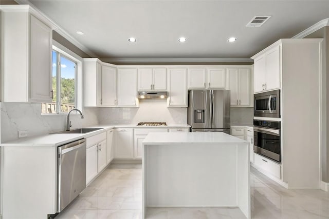7601 Crackling Creek Dr, Austin, TX 78736 - kitchen featuring stainless steel appliances, under cabinet range hood, ornamental molding, recessed lighting, and white cabinets