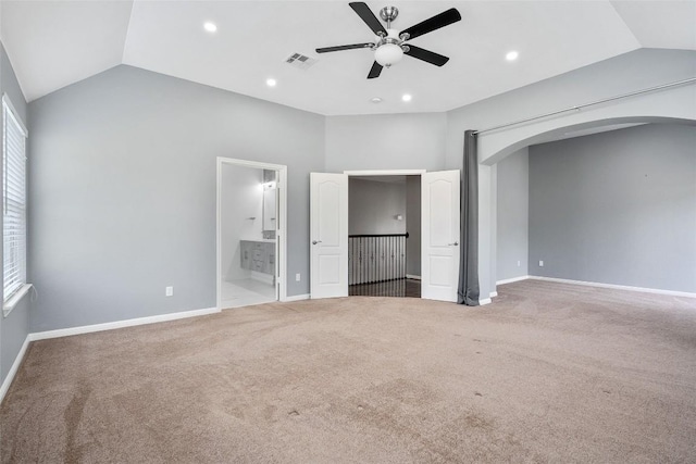 7601 Crackling Creek Dr, Austin, TX 78736 - unfurnished bedroom with vaulted ceiling, arched walkways, carpet flooring, multiple windows, and ensuite bath